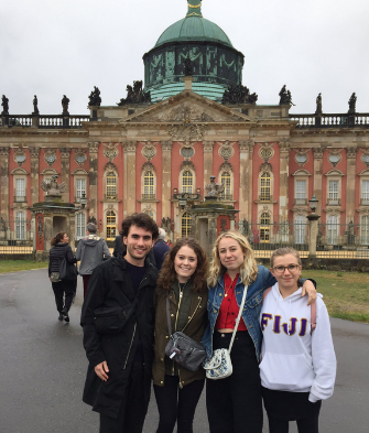 Four ATCJS undergraduate students outside an 18th century European castle during a summer program