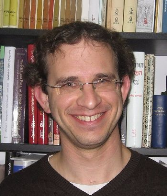 Nadav smiles with bookcase background 